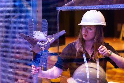 Woman holding parts of a wind turbine.