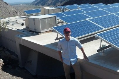 Tommy Jones standing in front of PV panels.