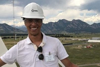 Headshot of a male smiling with a hard hat on.