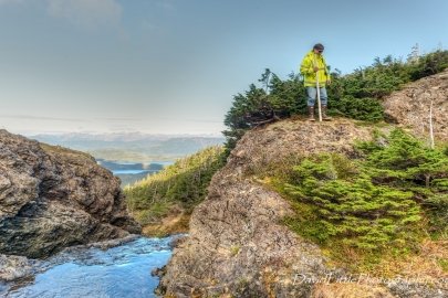 Person stands on a rock next to a creek.