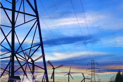 Wind turbines and grid towers against the sunset.