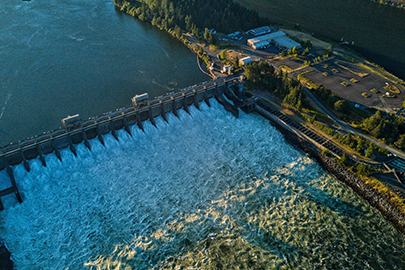 An aerial view of a small dam on one branch of a river that splits in two.