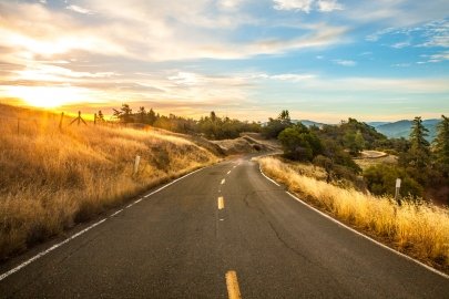 Empty road with a sunset on the left.