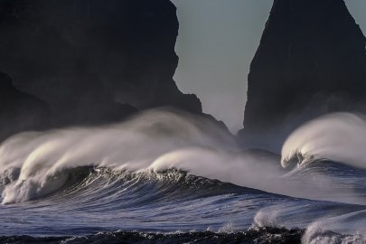 Ocean waves crash against rocks.