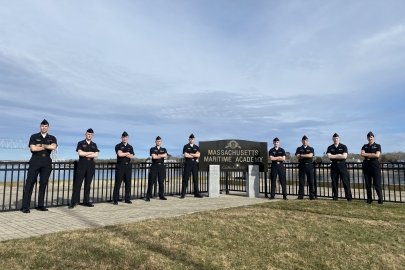 Massachusetts Maritime Academy team members stand on a pier.