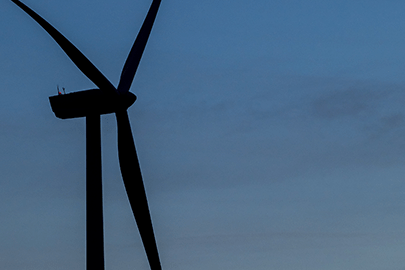 Silhouette of a wind turbine against the sky.