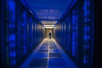 a photo of a person standing in an aisle of a high performance computer center
