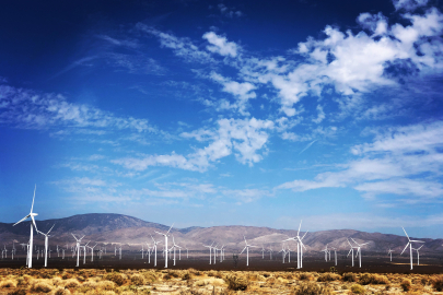 Land-Based wind turbine farm with mountains in the background.