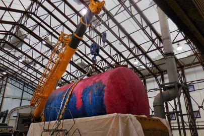 The last of seven tanks in the tank vault at the Separations Process Research Unit is hoisted for placement in a made-to-order shipping container.
