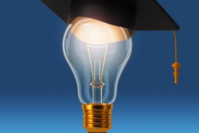 A lightbulb with a graduation cap on top of it.