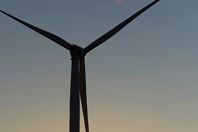 Wind turbine against a sunset.