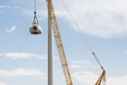 A crane removes parts of a wind turbine.