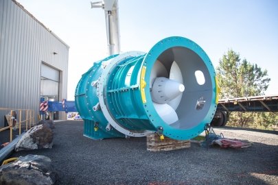 A large blue and white turbine is shown outside a warehouse building