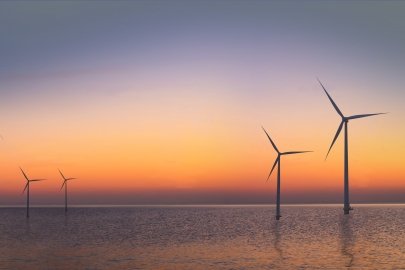 Offshore wind turbines against the sunset.