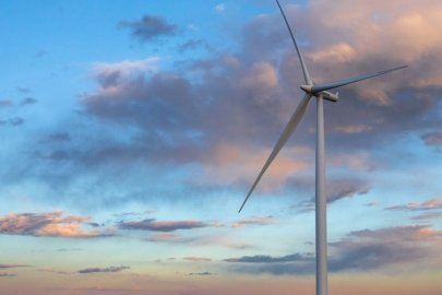 Sunset behind a lone wind turbine.