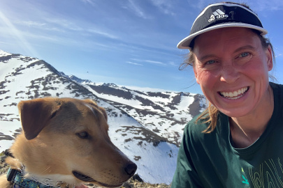 Dr. Erin Whitney and her dog, Barry, with the mountains behind them.  