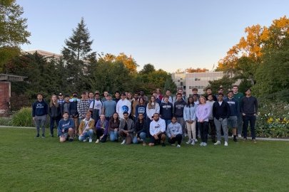Three rows of students standing or kneeling on a lawn.