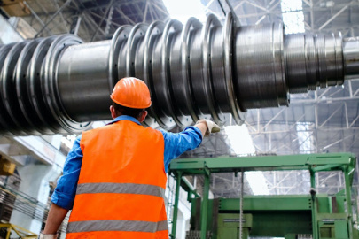 a photo of a person wearing a hard hat and a high visibility vest in a manufacturing facility
