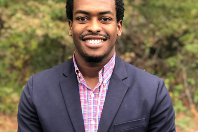 Headshot of Wendell Grinton in a suit and bright-colored button-up