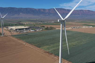 Two wind turbines in a large, open field.