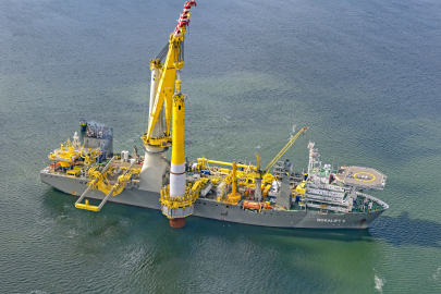 A barge carrying wind turbine equipment in the ocean