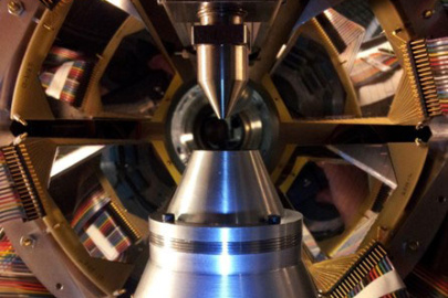 High resolution charged particle detectors surround the JENSA gas jet target, a system designed to provide point-like targets of gaseous elements such as helium for use in rare isotope beam experiments.