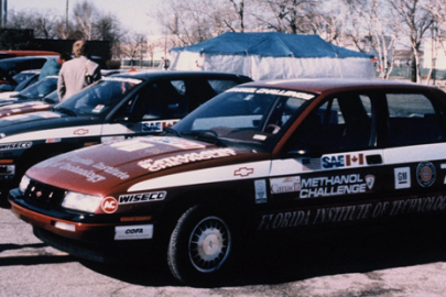 A row of 1988 Chevrolet Corsicas covered in stickers to show branding for the Methanol Challenge.