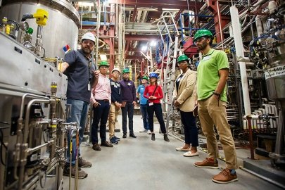 several people wearing hard hats in a manufacturing facility