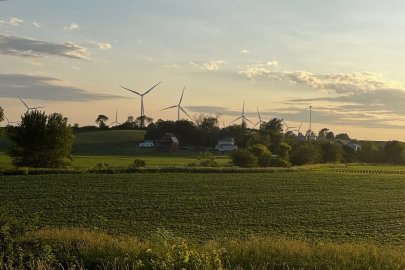 Wind turbines at the back of an open field. 