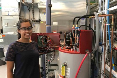 Jamie Santos standing next to residential water heater