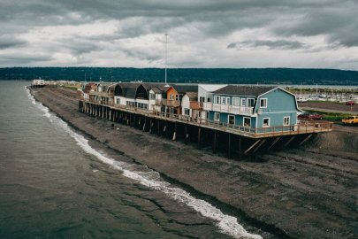 Several buildings sitting along a shoreline, over an embankment