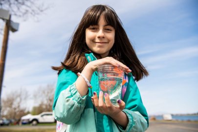A woman holding a jar with fish