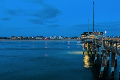 A pier and coastline seen at dusk