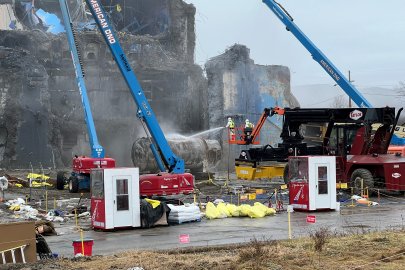Construction vehicles and equipment with workers demolishing a building