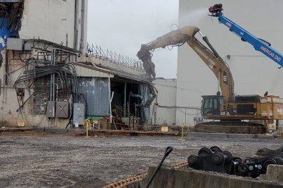 A building being demolished by large equipment machines 