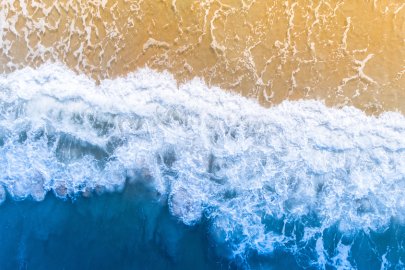Aerial view of waves washing up on a sandy beach