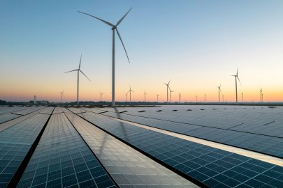Solar array and wind turbines at twilight.