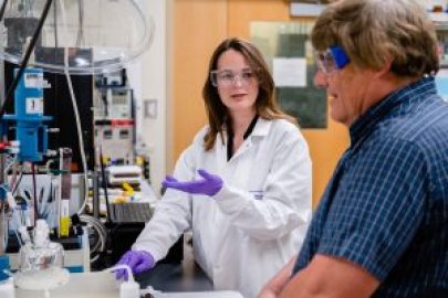 Two people in protective attire in a lab