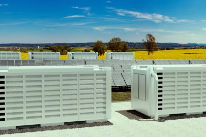 two large battery containers with a field of yellow in the foreground.  