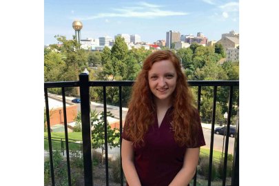 Headshot of Mary Daffron with Knoxville's skyline and Sunsphere in the background