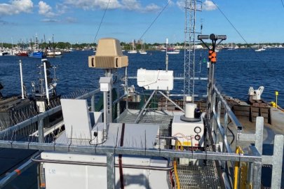 Radar equipment atop a floating barge in a large body of water. 