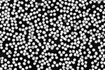 This electron microscope image shows spherical bismuth powder. Each particle in the photo is about the diameter of a human hair (approximately 60 micrometers).