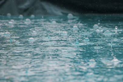 Closeup of rain drops splashing on a flat ocean surface