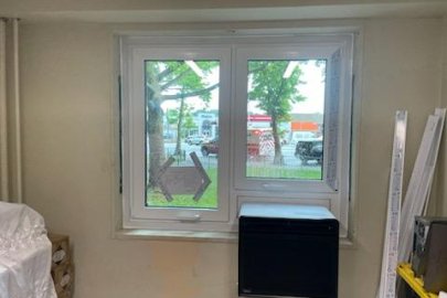 A window with a heat pump at the bottom. The inside view is inside a room
