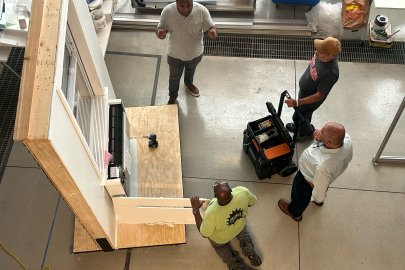 Overhead shot of men working on a window panel.