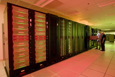two technicians standing in front of a large supercomputer.