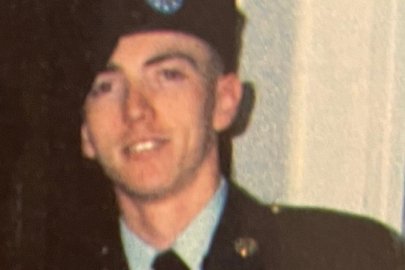 A man in a military uniform poses for a picture