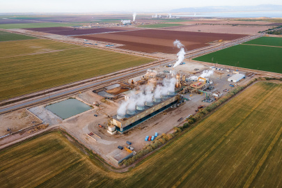 Geothermal power plant in the middle of yellow, brown, and green agricultural fields