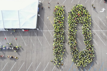 A large group of employees spelling out the number "10" with their bodies