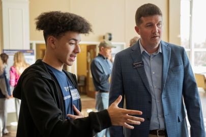 Paducah Innovation Hub student Jacob Hodge, standing left, explains his research findings to Murray State University Assistant Professor Eric Batts. 